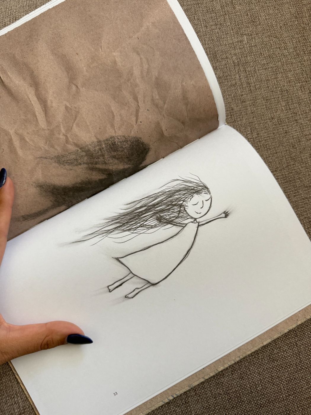 Desenho de uma menina de cabelos ao vento, em um livro aberto